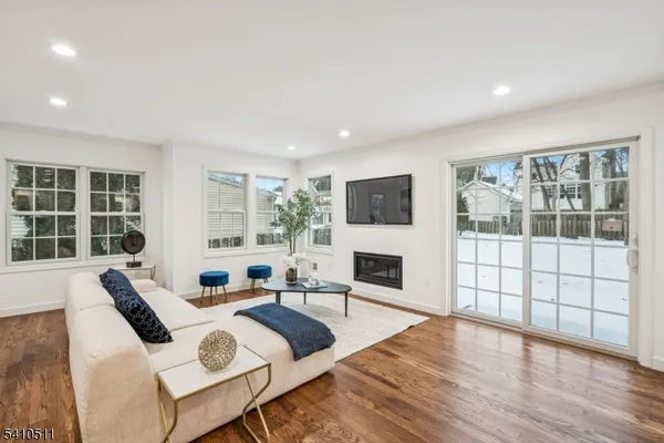 a living room with furniture a flat screen tv and a large window