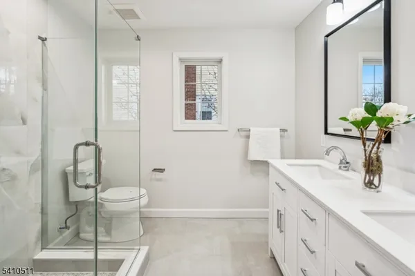 a bathroom with a granite countertop sink a toilet and shower