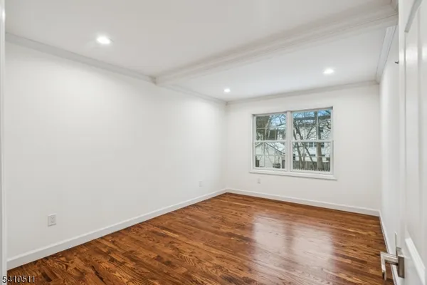 an empty room with wooden floor and window