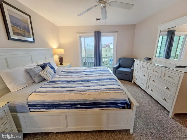 a bedroom with a bed and dresser with mirror