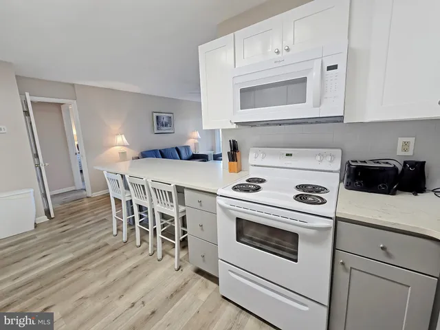 a kitchen with a stove a microwave and wooden floor