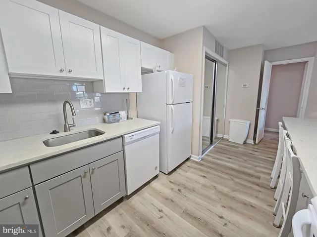 a kitchen with white cabinets and white appliances