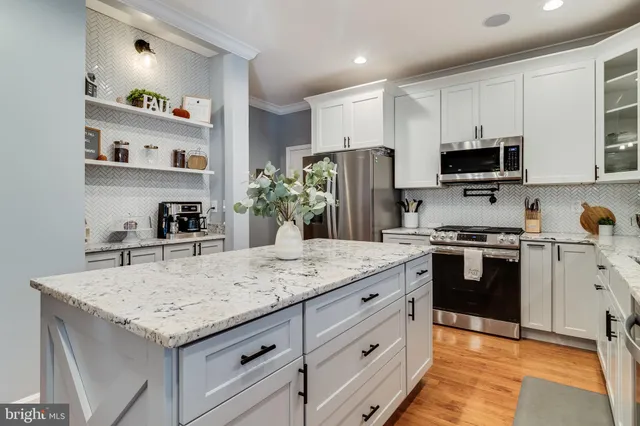 a kitchen with granite countertop a sink stove and refrigerator