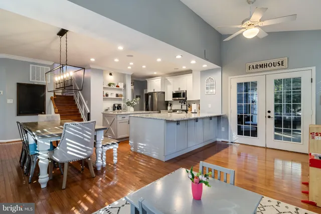 a living room with furniture kitchen view and a chandelier