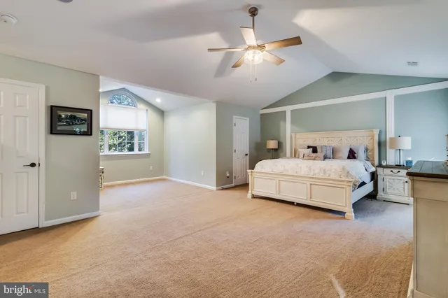 a spacious bedroom with a bed and ceiling fan