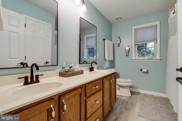 a bathroom with double sink and a mirror