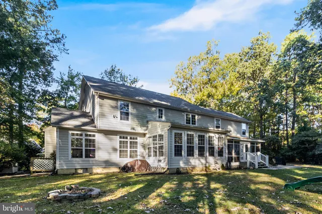 a front view of a house with a garden and trees
