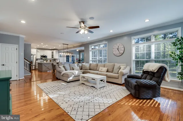 a living room with furniture kitchen view and a large window