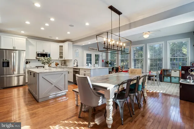 a view of a dining room and livingroom with furniture wooden floor a chandelier