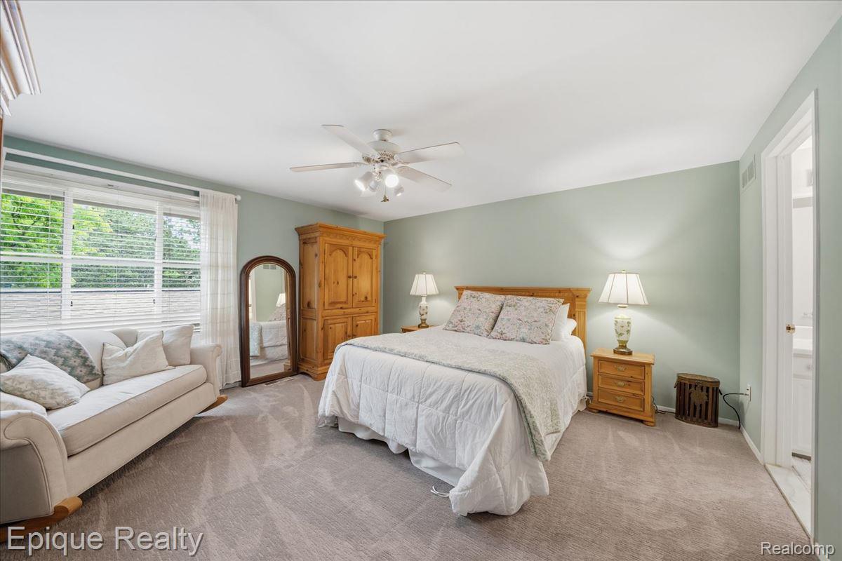 26 Kirks Court Rochester, MI 48309 - Photo 21 of 44 Carpeted room featuring light green walls and a white ceiling with a ceiling fan