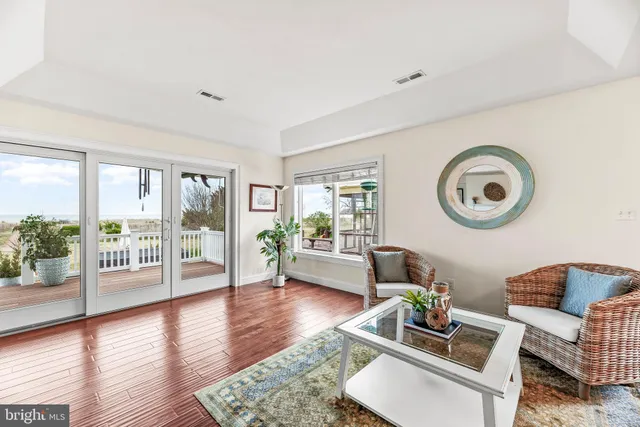 a living room with furniture a chandelier and a large window