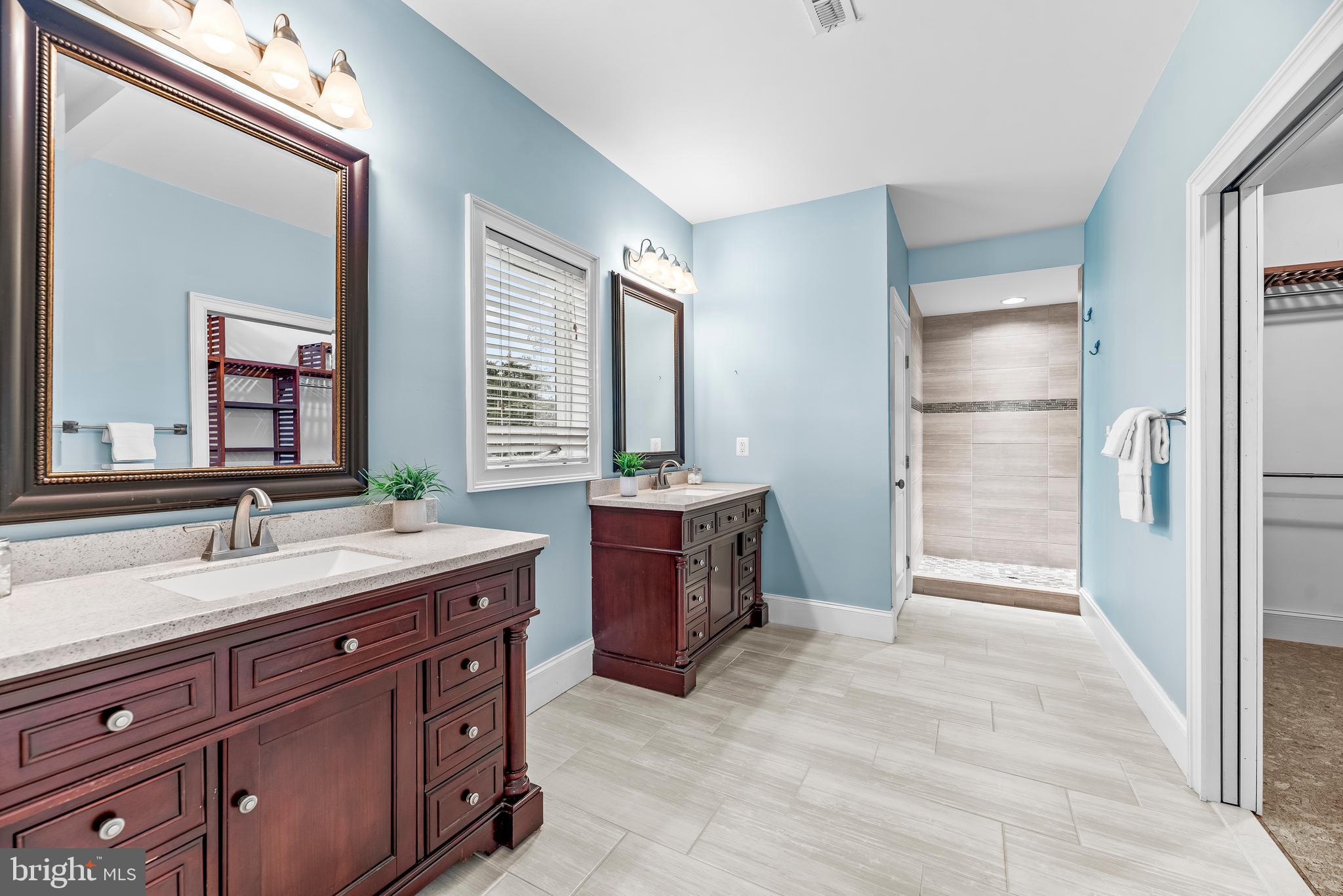 3095 Calvert Boulevard Lusby, MD 20657 - Photo 47 of 105 a spacious bathroom with a sink double vanity and a mirror