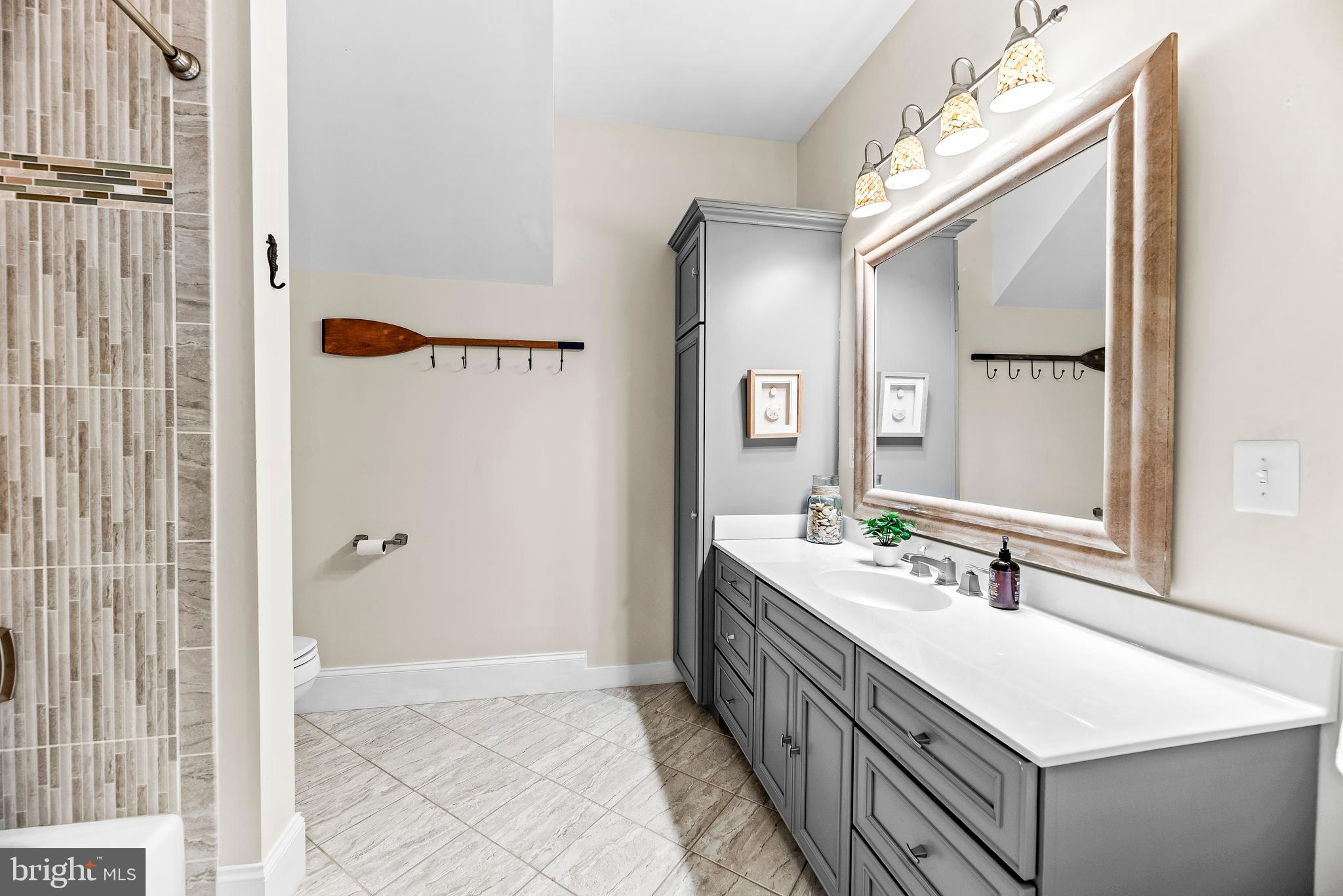 3095 Calvert Boulevard Lusby, MD 20657 - Photo 56 of 105 a bathroom with a double vanity sink a mirror and a shower