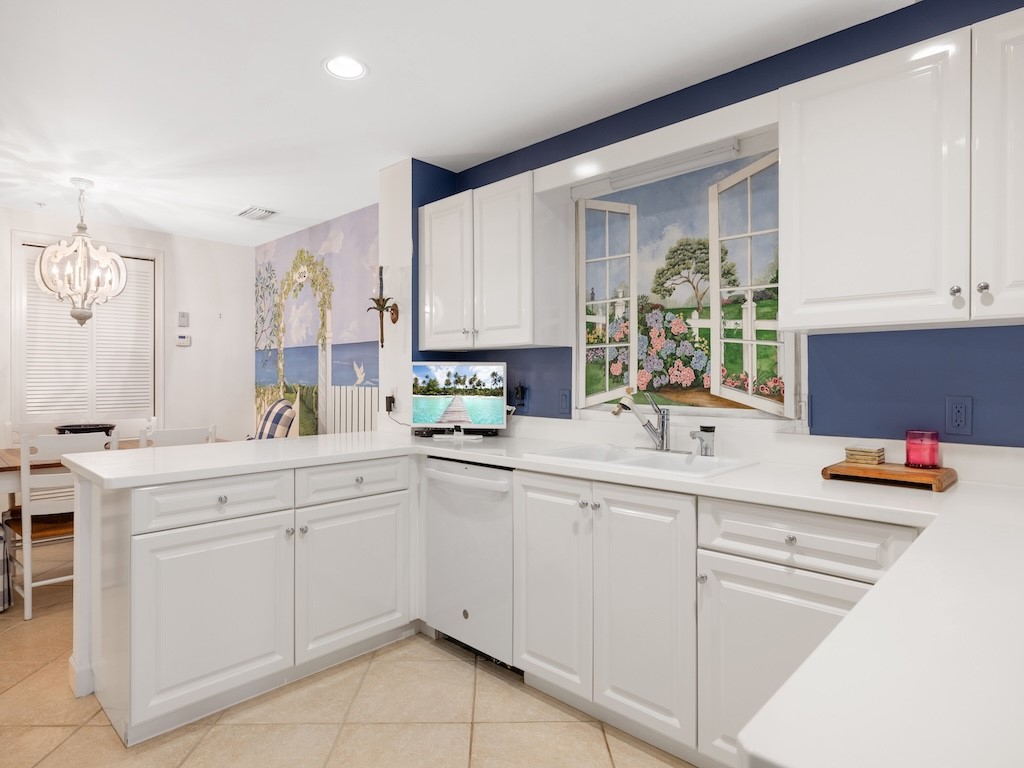 940 Turtle Cove Lane, Unit 302 Vero Beach, FL 32963 - Photo 11 of 30 a kitchen with white cabinets and sink