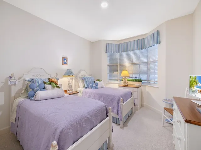 a bedroom with two beds and painting on the wall