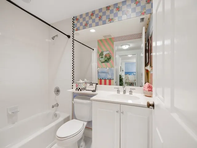 a bathroom with a sink vanity mirror toilet and bathtub