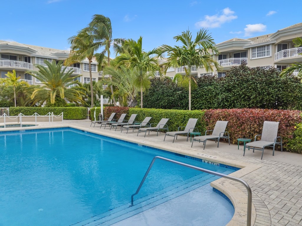 940 Turtle Cove Lane, Unit 302 Vero Beach, FL 32963 - Photo 29 of 30 a view of a swimming pool with a lounge chairs
