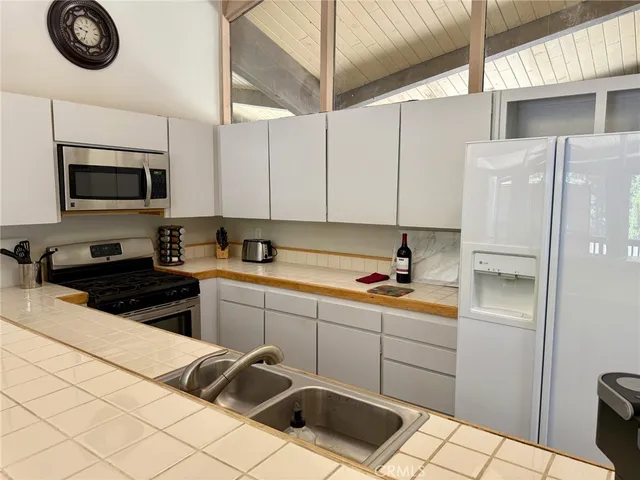 a kitchen with stainless steel appliances a sink a stove a microwave and a refrigerator