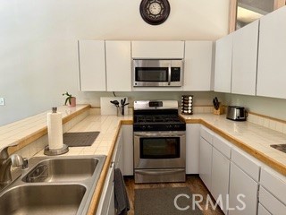 872 Sierra Vista Drive Twin Peaks, CA 92391 - Photo 13 of 37 a kitchen with a sink stove and microwave
