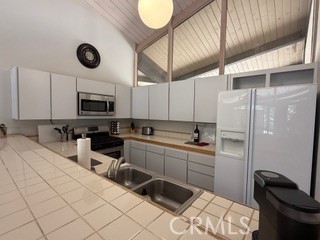 872 Sierra Vista Drive Twin Peaks, CA 92391 - Photo 16 of 37 a kitchen with stainless steel appliances a sink a stove a refrigerator cabinets and furniture