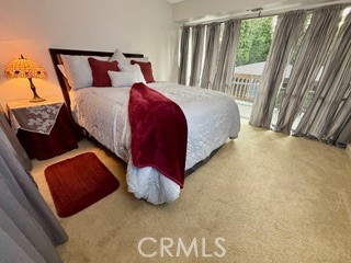 872 Sierra Vista Drive Twin Peaks, CA 92391 - Photo 21 of 37 a bedroom with a bed lamp and a large window