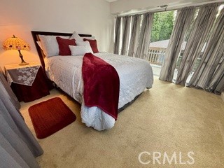 872 Sierra Vista Drive Twin Peaks, CA 92391 - Photo 22 of 37 a bedroom with a bed lamp and a large window