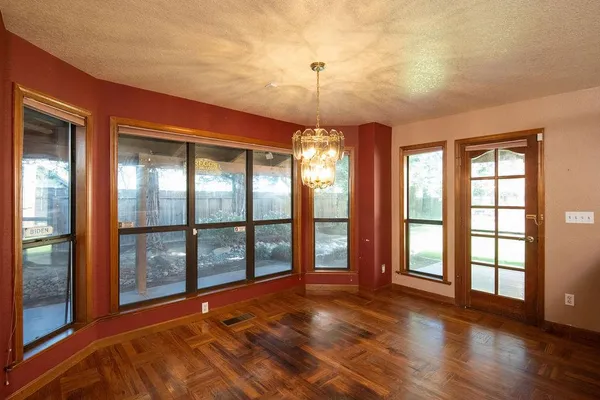 an empty room with windows and fireplace
