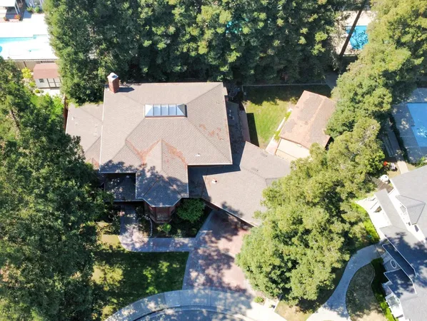 an aerial view of a house with garden space and a yard