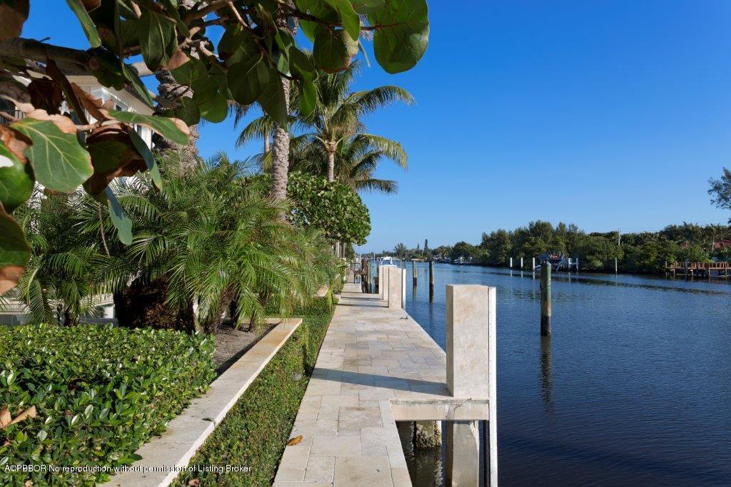 95 Curlew Road Manalapan, FL 33462 - Photo 35 of 36 a view of a lake with a floor to ceiling window and potted plants