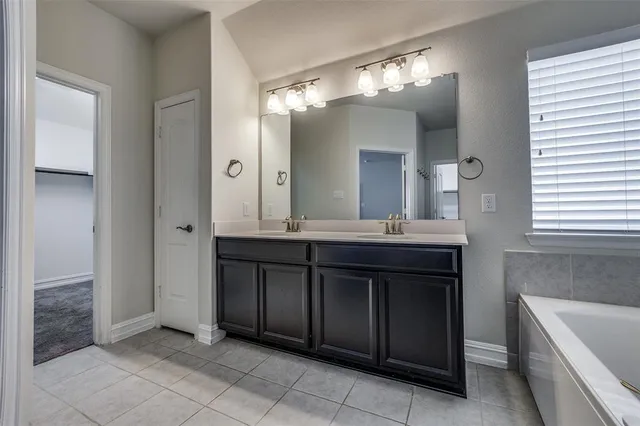 a bathroom with a granite countertop sink a large mirror and a bathtub