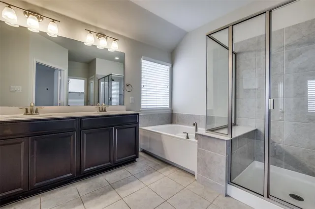 a spacious bathroom with a tub sink shower and mirror
