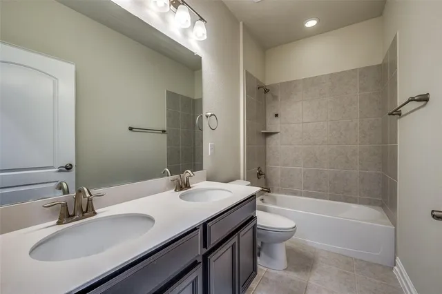 a bathroom with a granite countertop sink a toilet and shower