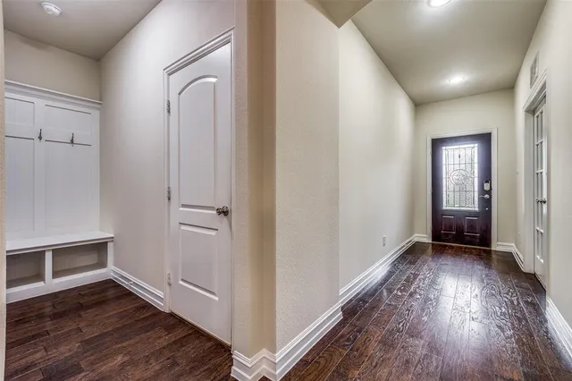 an empty room with wooden floor a fireplace and windows
