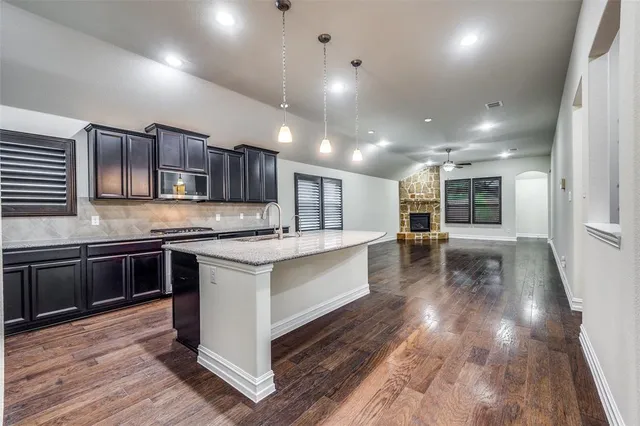 a kitchen with stainless steel appliances granite countertop wooden cabinets a stove top oven a sink and dishwasher