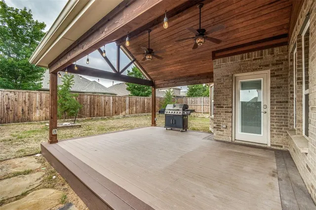 a view of a backyard with table and chairs and wooden fence