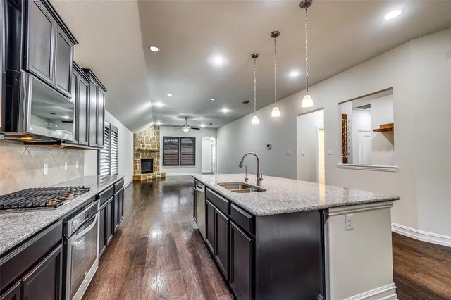 a kitchen with stainless steel appliances granite countertop a sink stove and cabinets