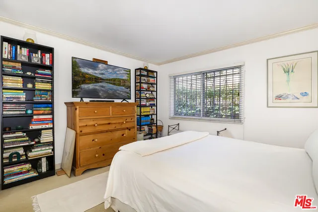 a bedroom with a bed and a book shelf