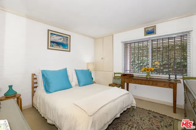 a bedroom with bed and a large window