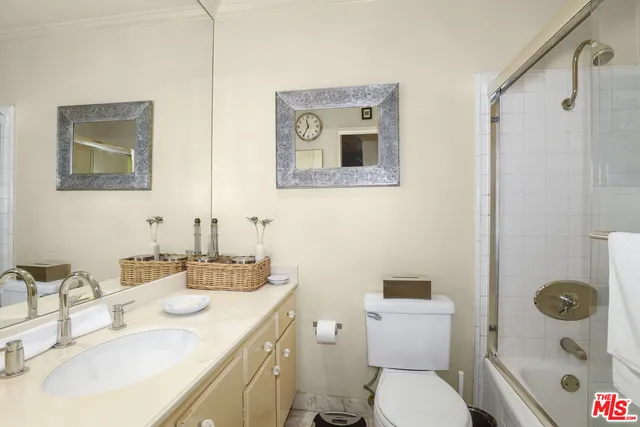 a bathroom with a toilet sink vanity tub and mirror