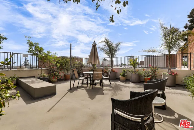a view of a patio with couches table and chairs and potted plants