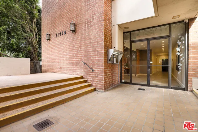 a view of a patio with a bench and door