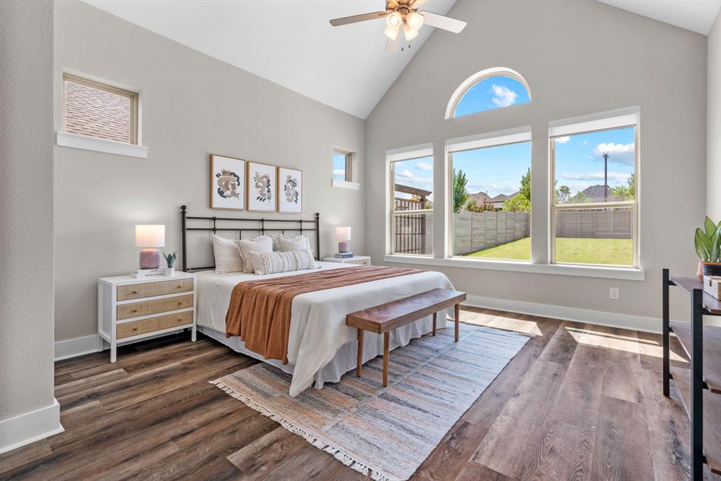 1821 Stonewall Road Argyle, TX 76226 - Photo 15 of 40 Vaulted ceilings with a ceiling fan, wood-finish flooring, and a large arched window above three expansive windows