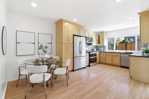 a kitchen with white cabinets and stainless steel appliances