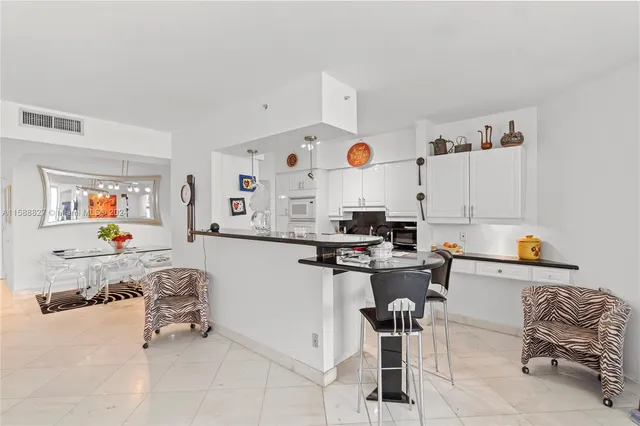 a kitchen with stainless steel appliances kitchen island granite countertop a refrigerator and a stove