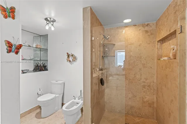 a bedroom with a bed a dresser and next to a window