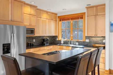 a kitchen with a table chairs and cabinets