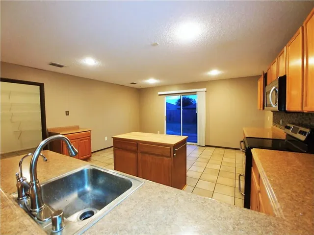 a kitchen with sink and mirror
