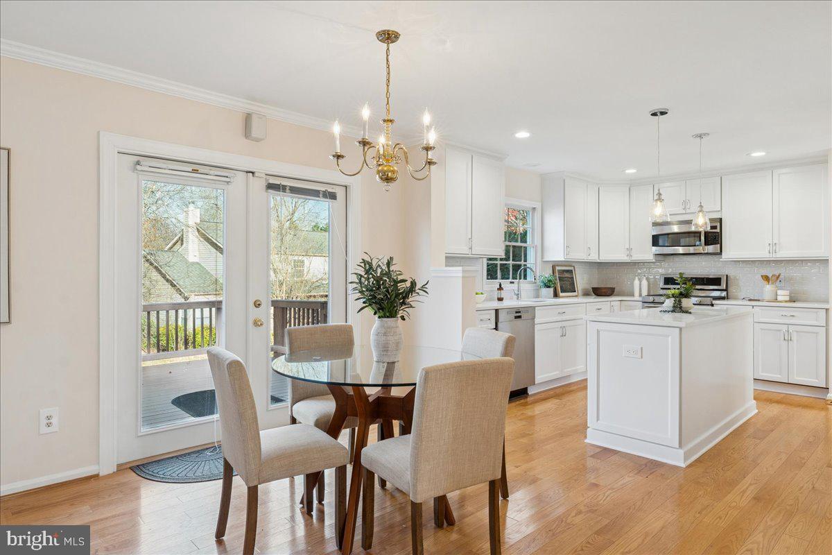 12546 Rock Ridge Road Herndon, VA 20170 - Photo 13 of 44 a kitchen with stainless steel appliances kitchen island granite countertop a dining table chairs and white cabinets