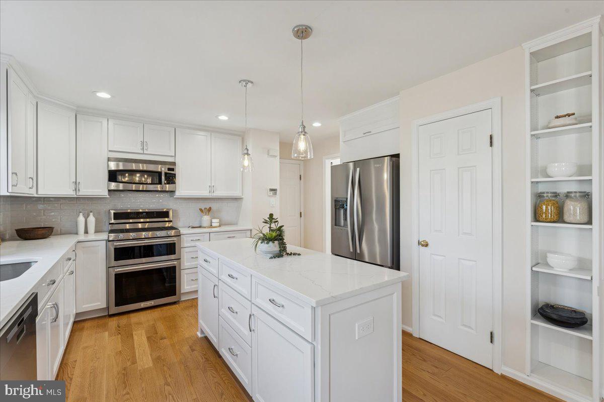 12546 Rock Ridge Road Herndon, VA 20170 - Photo 14 of 44 a large kitchen with granite countertop a stove and a refrigerator