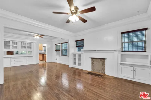 a view of an empty room with window and wooden floor